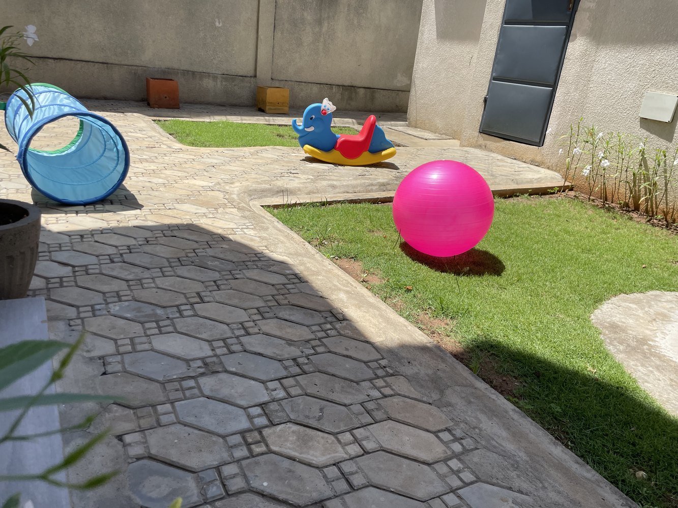 Cour de jeu avec ballon, tunnel bleu et petit jeu à bascule