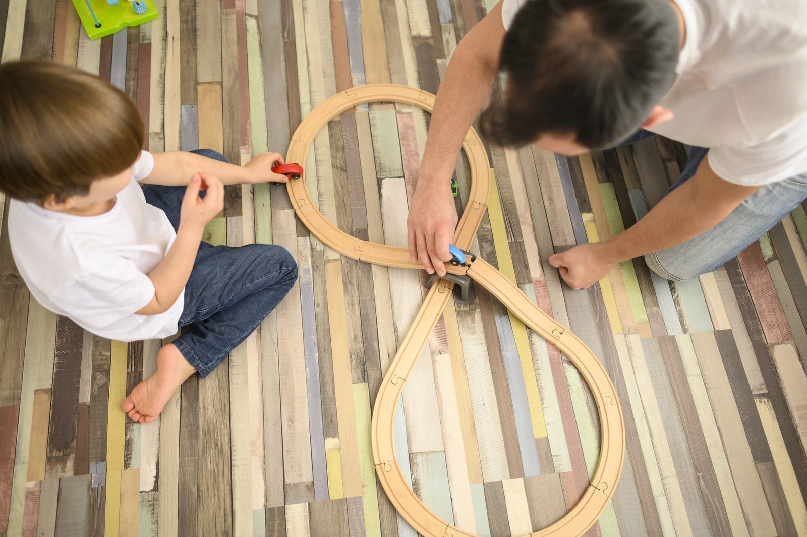 Jeu de train en bois accompagné par un adulte